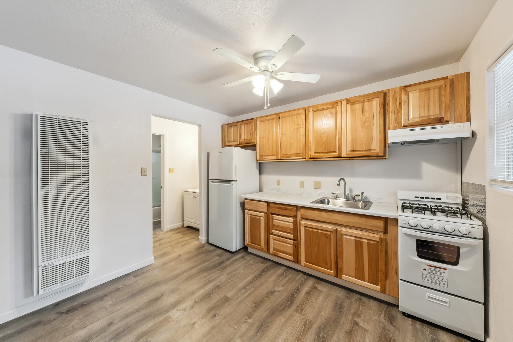 Remodeled apartment kitchen with wood cabinets and new counters
