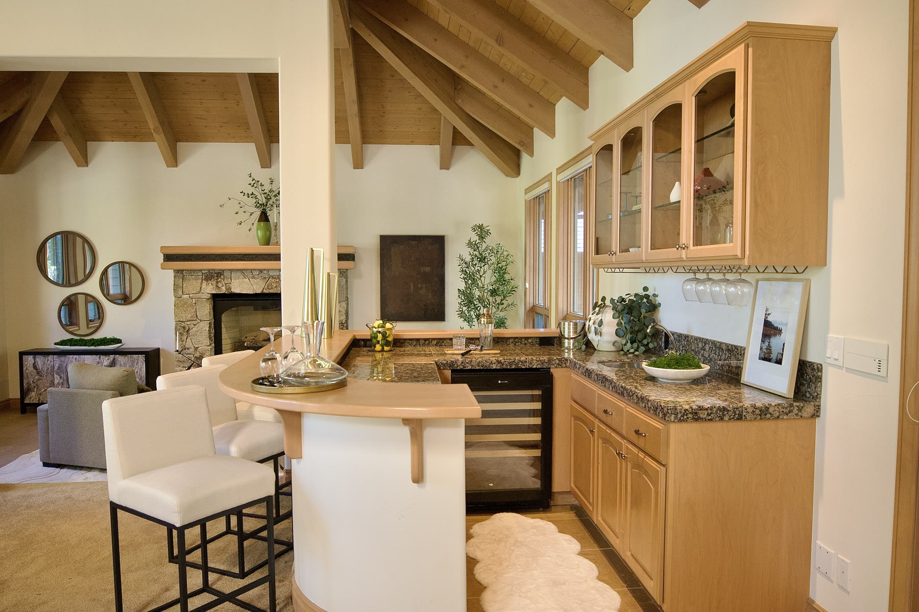 Staged bar with white stools, looking through to the fireplace sitting room